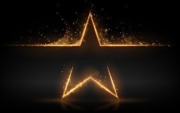 A golden star on a black background with computer support.