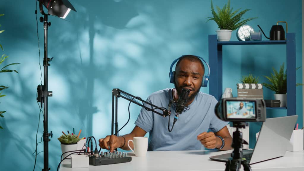 A man is sitting at a desk with a microphone and a laptop providing computer tech support in Naples, Florida.