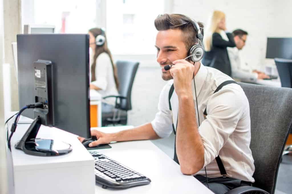 A man providing computer support in front of a computer.