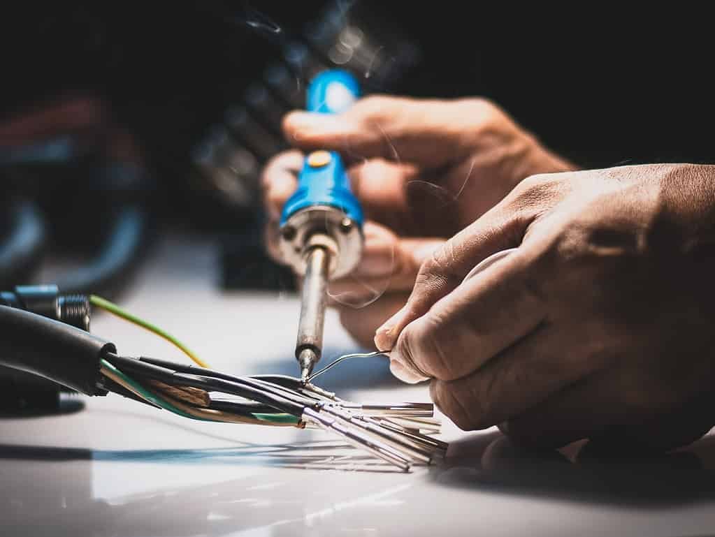 34031130 electricians are using a soldering iron to connect the wires to