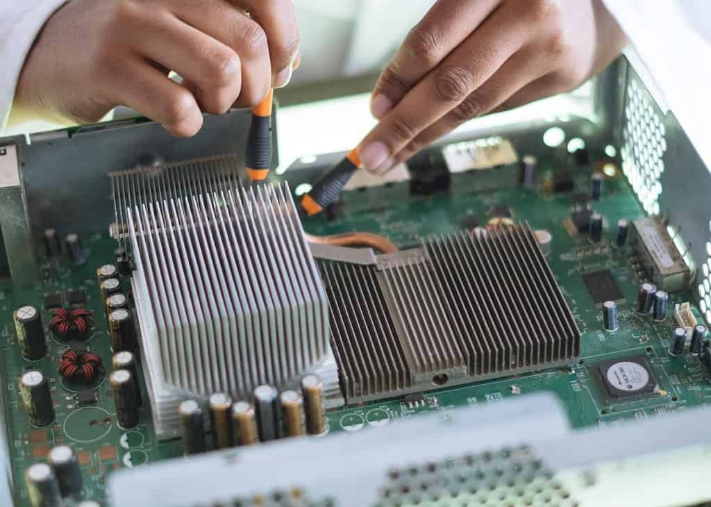 A person is working on a computer motherboard with IT support in Naples, Florida.