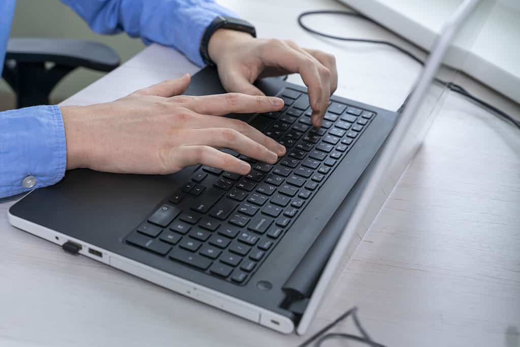 44672872 close up of mans hand typing on laptop keyboard