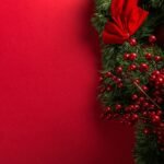 A festive wreath on a vibrant red background.