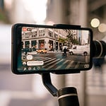 A smartphone with camera support is being used to take a picture of a city.