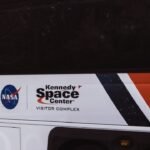 The nasa bus is parked in front of a building.