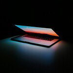 A laptop is lit up in the dark.