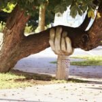 A statue of a hand on a tree.